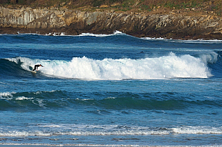 Surfař na pláži Zurriola hondartza v San Sebastian (Španělsko)