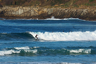 Surfař na pláži Zurriola hondartza v San Sebastian (Španělsko)